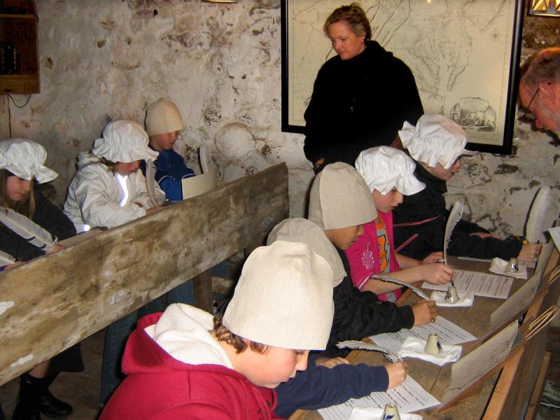 Children in classroom using quill pens