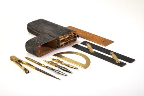 a pair of brass, ebony parallel rulers, a brass protractor, ruler