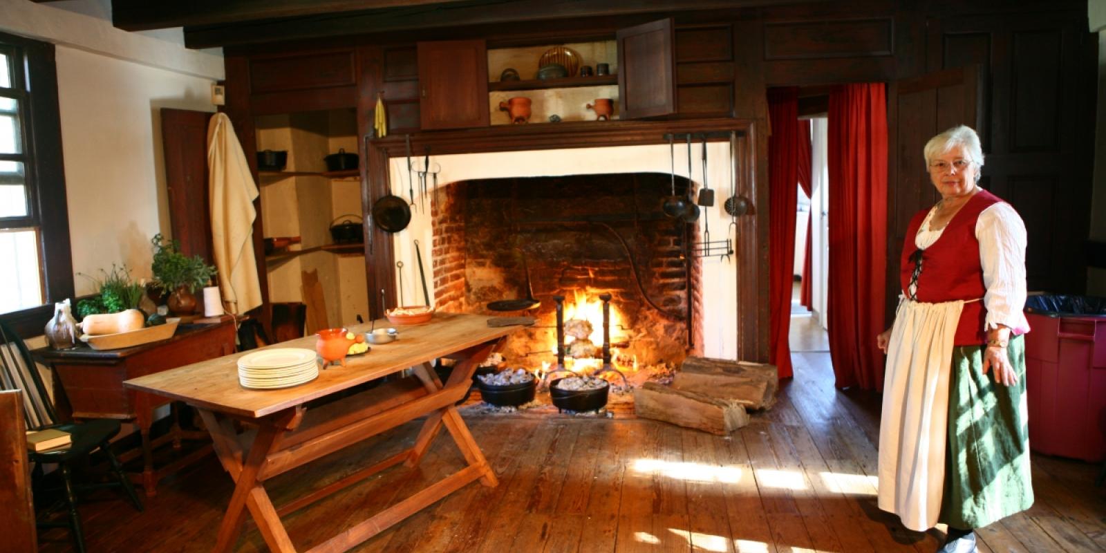 Woman in colonial dress at large hearth